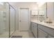 Bathroom featuring a shower with glass door, double sink vanity, and a wall mirror at 404 Cattle Drive Circle, Myrtle Beach, SC 29588