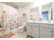 Bathroom featuring a floral shower curtain, double sink vanity, and neutral color scheme at 404 Cattle Drive Circle, Myrtle Beach, SC 29588