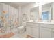 Bright bathroom features double sinks, gray cabinets, and a tub-shower with floral shower curtain at 404 Cattle Drive Circle, Myrtle Beach, SC 29588