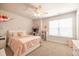 Bright bedroom with a plush bed, ceiling fan, desk, and window bringing in natural light at 404 Cattle Drive Circle, Myrtle Beach, SC 29588