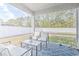 Covered porch features stylish seating overlooking the lush green lawn and trees at 404 Cattle Drive Circle, Myrtle Beach, SC 29588