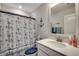 Nautical themed bathroom with white vanity, framed mirror, and shower with anchor patterned curtain at 4123 Mclamb Ave. # 4123, Little River, SC 29566