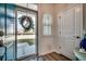 Inviting foyer with wood floors and coastal-themed decor and wreath on the glass front door at 4123 Mclamb Ave. # 4123, Little River, SC 29566