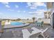 Inviting backyard featuring a pool, comfortable lounge chairs, and an outdoor dining area under a bright blue sky at 414 S Dogwood Dr., Garden City Beach, SC 29576