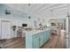 Open concept kitchen island with turquoise cabinets and marble countertop, leading to dining area at 414 S Dogwood Dr., Garden City Beach, SC 29576