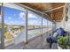 A covered porch with a seating area offers views of the river, pool, and gazebo on a sunny day at 414 S Dogwood Dr., Garden City Beach, SC 29576