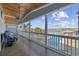 Covered porch with water views, featuring comfortable seating and an outdoor fan for relaxation at 414 S Dogwood Dr., Garden City Beach, SC 29576