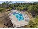 Aerial view of a community pool, with lounge chairs and palm trees on a sunny day at 4142 Hibiscus Dr. # 104, Little River, SC 29566