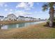 Scenic backyard view overlooking a tranquil pond and neighboring houses at 4142 Hibiscus Dr. # 104, Little River, SC 29566