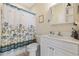 Traditional bathroom with floral shower curtain, white vanity, sink, and mirrored medicine cabinet at 4142 Hibiscus Dr. # 104, Little River, SC 29566