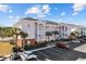 Charming multi-Gathering home with palm trees and a well-maintained parking lot on a sunny day at 4142 Hibiscus Dr. # 104, Little River, SC 29566