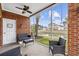 Relaxing screened-in porch with brick wall, ceiling fan, and views of the yard and pond at 4142 Hibiscus Dr. # 104, Little River, SC 29566