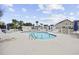 Community pool surrounded by a white fence, lounge chairs, and palm trees on a sunny day at 4142 Hibiscus Dr. # 104, Little River, SC 29566