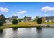 Backyard view featuring serene pond, lawn, and the home's exterior with white fenced in area at 4387 Heartwood Ln., Myrtle Beach, SC 29579