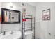 Compact bathroom with a pedestal sink, framed mirror, and open shelving above the toilet at 450 Deer Spring Loop, Georgetown, SC 29440