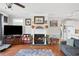 Inviting living room with a cozy fireplace, hardwood floors, a large TV, and comfortable gray sofa at 450 Deer Spring Loop, Georgetown, SC 29440