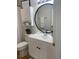 Bathroom with a white vanity, white cabinet and a round mirror at 4637 Lightkeepers Way # 4-A, Little River, SC 29566