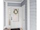 Charming entryway with white door, glass panel, wreath, welcome mat and light blue siding at 4637 Lightkeepers Way # 4-A, Little River, SC 29566