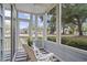 Relaxing screened porch with white chairs and neutral-striped rug at 4637 Lightkeepers Way # 4-A, Little River, SC 29566