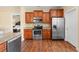 Modern kitchen showcasing stainless steel appliances, hardwood floors, and wood cabinets near the Primary bedroom entrance at 494 Battey Dr., Myrtle Beach, SC 29588