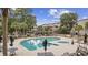 A large outdoor pool with a hot tub is surrounded by palm trees and tables with buildings in the background at 501 Maison Dr. # F-1, Myrtle Beach, SC 29572