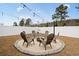 Backyard featuring a charming stone firepit area with ample seating and string lights at 5064 Wavering Place Loop, Myrtle Beach, SC 29579