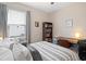 Comfortable bedroom featuring a striped bedspread, desk area, and large window at 5064 Wavering Place Loop, Myrtle Beach, SC 29579