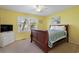 Cozy bedroom with yellow walls, wood sleigh bed, and a window providing natural light and street view at 508-B Rosemary Ln., North Myrtle Beach, SC 29582