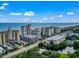 Aerial view showcasing oceanfront condos with a pond, parking, and tennis courts at 5308 N Ocean Blvd. # 1003, Myrtle Beach, SC 29577