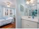 Bathroom with a single sink vanity, framed mirror, and light blue walls is connected to the bedroom at 701 1St Ave. S # 32C, North Myrtle Beach, SC 29582