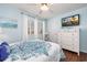 Bedroom with hardwood floors, and a large TV, features a white dresser, and a cozy feel at 701 1St Ave. S # 32C, North Myrtle Beach, SC 29582