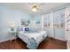 Bright bedroom features a white and blue patterned bedspread, hardwood floors, and an abundance of natural light at 701 1St Ave. S # 32C, North Myrtle Beach, SC 29582