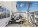 View of a golf cart parked on a paved area next to a white building at 701 1St Ave. S # 32C, North Myrtle Beach, SC 29582