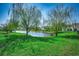 Beautiful backyard view featuring a pond, weeping willow trees, and lush green grass at 808 Yauhannah Dr., Little River, SC 29566