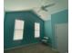 Bedroom with bright blue walls, carpet flooring, two windows, and a white chair at 808 Yauhannah Dr., Little River, SC 29566