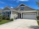 Charming home exterior with neutral siding, rocking chairs on the porch, and a two-car garage at 808 Yauhannah Dr., Little River, SC 29566