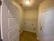 Neutral-colored laundry room with vinyl flooring includes hookups, shelving, and a door to the exterior at 808 Yauhannah Dr., Little River, SC 29566
