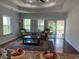 Cozy living room featuring a tray ceiling, large windows with shutters, and access to a screened porch at 808 Yauhannah Dr., Little River, SC 29566