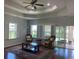 Cozy living room featuring a tray ceiling, large windows with shutters, and access to a screened porch at 808 Yauhannah Dr., Little River, SC 29566