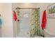 White bathroom featuring a large shower with colorful curtain, and an adjacent white sink and vanity at 845 Hall Lane # B, Myrtle Beach, SC 29577