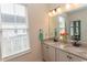 Bright bathroom with dual sinks, granite countertops, a large mirror, and natural light from the window at 845 Hall Lane # B, Myrtle Beach, SC 29577