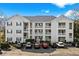 A view of the condo's exterior with white siding and parking in front under a blue sky at 901 West Port Dr. # 1611, North Myrtle Beach, SC 29582