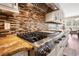 Modern kitchen features stainless steel stove, custom hood, and backsplash with adjacent seating area at 915 Preservation Circle, Pawleys Island, SC 29585