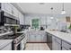Well-lit kitchen showcases updated appliances, gray cabinetry, neutral countertops, and convenient dishwasher at 945 Castlewood Dr., Conway, SC 29526