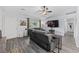 Cozy living room featuring a gray sectional, wood-look floors, and a large wall-mounted television at 945 Castlewood Dr., Conway, SC 29526