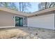 Neutral-colored home featuring an attached white garage with a sliding glass door at 2212 Old Charleston Rd., Georgetown, SC 29440
