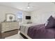 Bright bedroom with hardwood floors, ceiling fan, and a dresser with decorative mirror at 1012 Dowitcher Dr., Conway, SC 29526