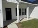 Close-up of the front entrance, showcasing the black door, white columns, house number, and a glimpse of the front lawn at 10534 W Highway 19, Loris, SC 29569