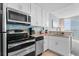 Bright kitchen features stainless steel appliances, granite countertops, and blue glass tile backsplash at 107 S Ocean Blvd. # 2106, Myrtle Beach, SC 29577