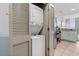 Convenient laundry area featuring stacked washer and dryer units, with a partial view of the kitchen at 107 S Ocean Blvd. # 2106, Myrtle Beach, SC 29577